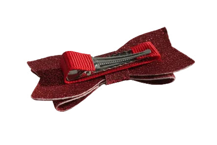 Red glittery hair clip with a red clip on a white surface
