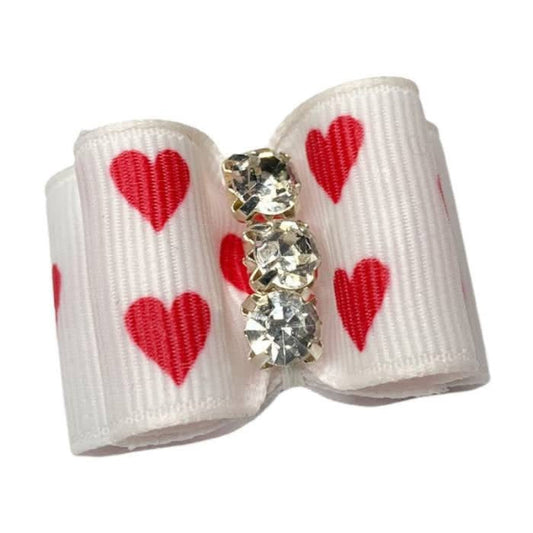 White bow with red hearts and crystal embellishments on a white background