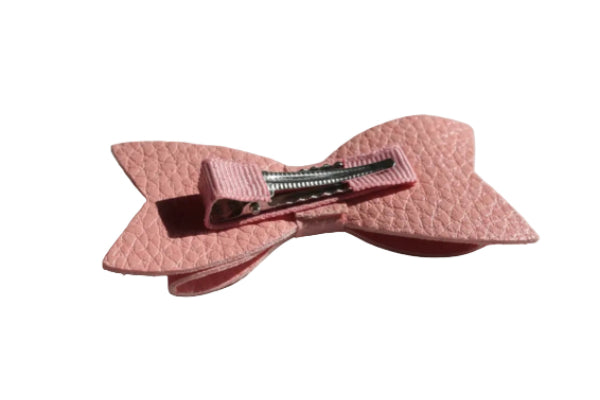 Pink textured hair bow on a white surface 1