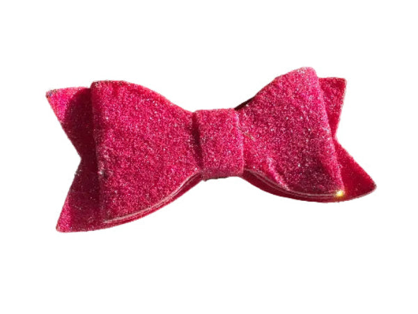 Phot pink glittery bow on a light gray surface