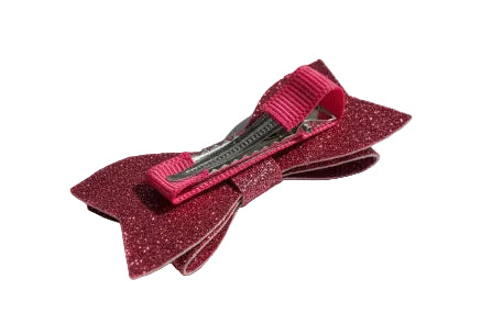 Pink glittery hair bow on a white surface